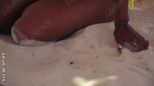 pretty black girl in yellow bikini resting on the  beach