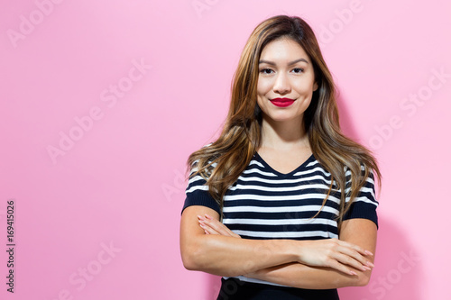 Happy young woman on a pink background photo