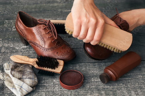 Craftsman cleaning shoe with brush