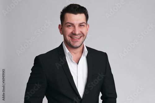 Cheerful handsome smiling man in black suit