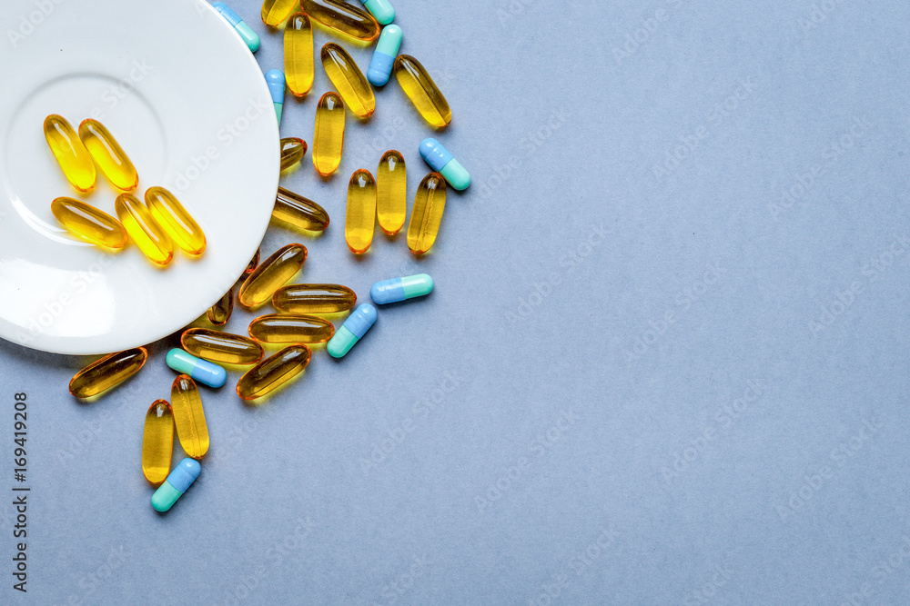 colorful medical pills on saucer gray background colorful medical pills on saucer gray background