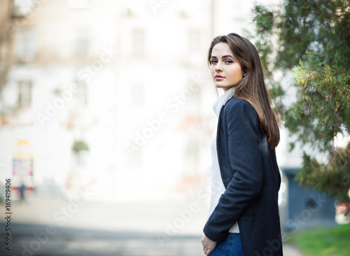 Young beautiful woman portrait posing in city