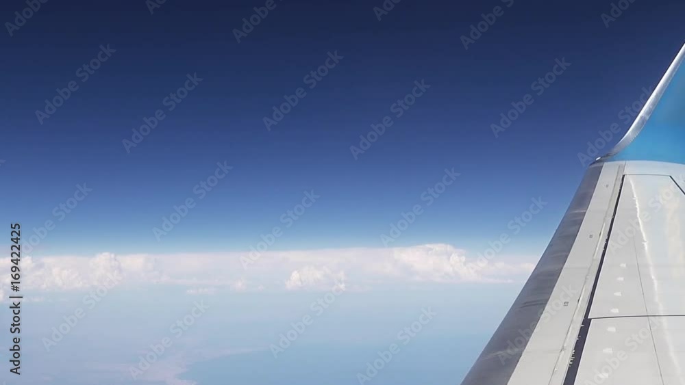 Flying over the clouds. View from plane aircraft passenger window. Clouds and skyline horizon panoramic view. Flying over the clouds. View from plane aircraft passenger window. Clouds and skyline horizon panoramic view.