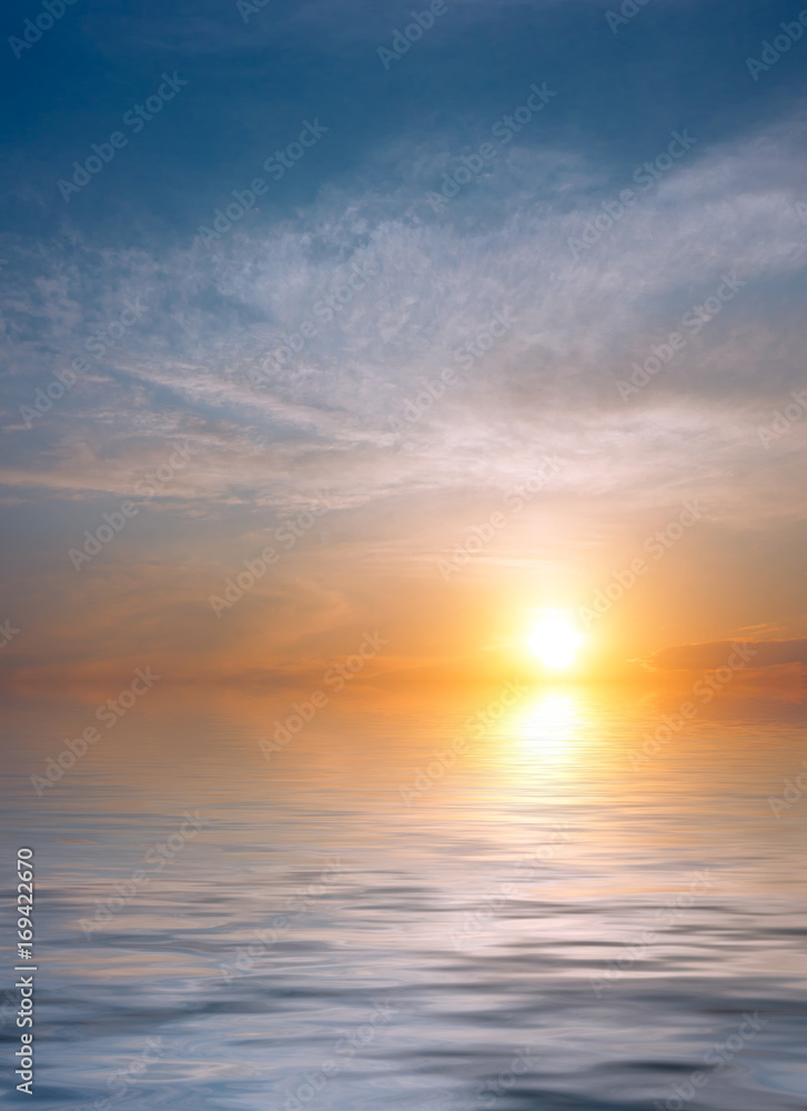 A calm dawn on the sea, soft clouds and sun.