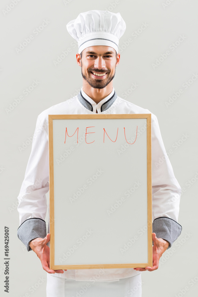 Chef is holding whiteboard on gray background. Chef is holding whiteboard on gray background.
