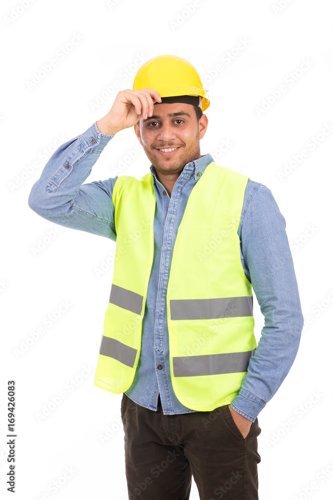 Happy young engineer smiling and holding his helmet, guy wearing blue shirt and jeans with yellow vest, isolated on white background Happy young engineer smiling and holding his helmet, guy wearing blue shirt and jeans with yellow vest, isolated on white background