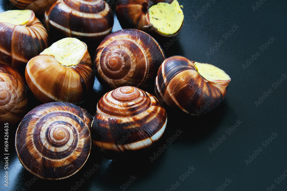 Snails on a dark plate. French dish. Snails on a dark plate. French dish.