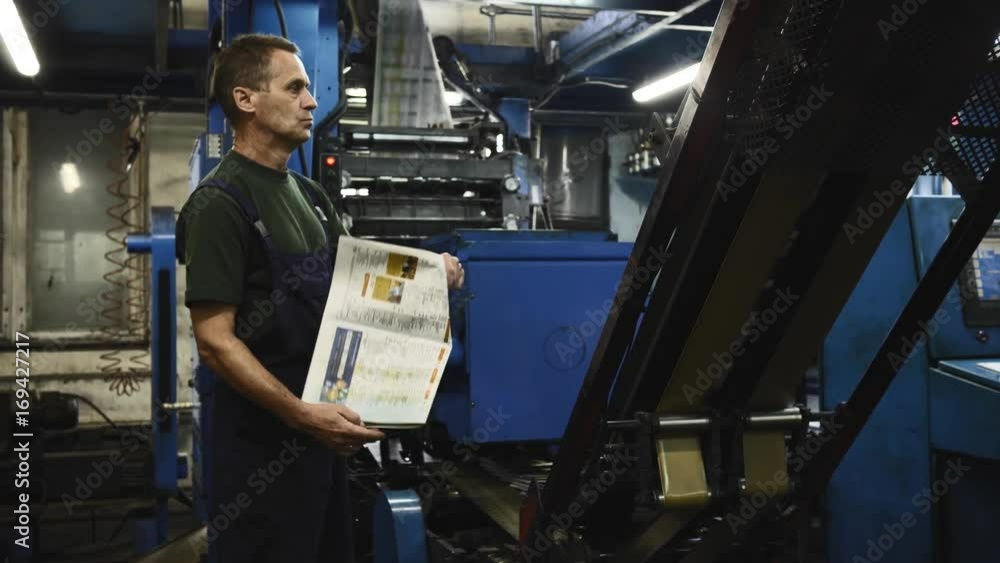 Close up of a worker s hand adjusting print quality and pushing a button of a printing plant machine. Locked down real time close up shot Close up of a worker s hand adjusting print quality and pushing a button of a printing plant machine. Locked down real time close up shot