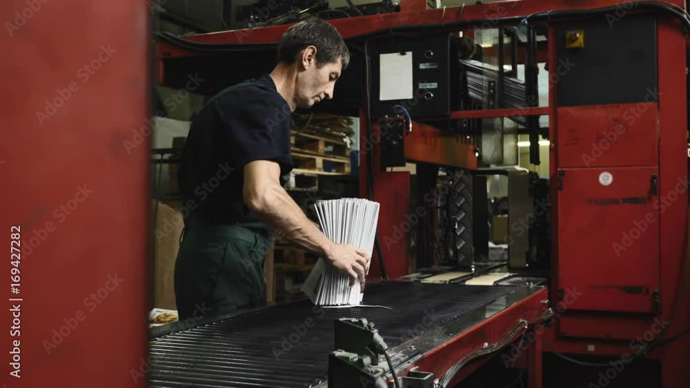 man working on newspaper production line in newspaper factory, printing house man working on newspaper production line in newspaper factory, printing house