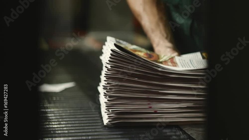 man working on newspaper production line in newspaper factory, printing house