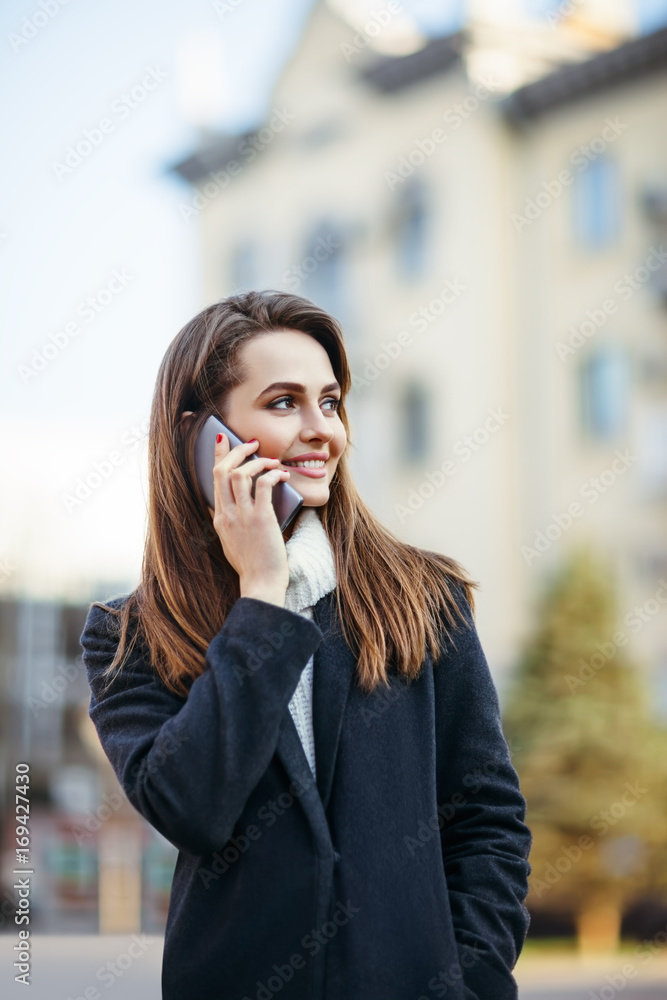 Beautiful woman speaking on mobile phone on the city street Beautiful woman speaking on mobile phone on the city street