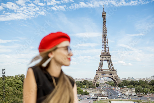 Portrait of a young happy woman in red cap in front of the Eiffel tower in Paris. Woman is out of focus © rh2010