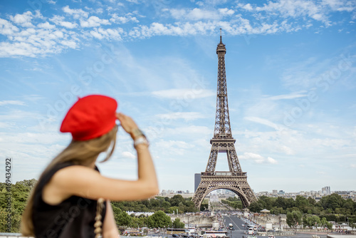 Young woman in red cap and pants enjoying great view on the Eiffel tower in Paris. Woman is out of focus © rh2010