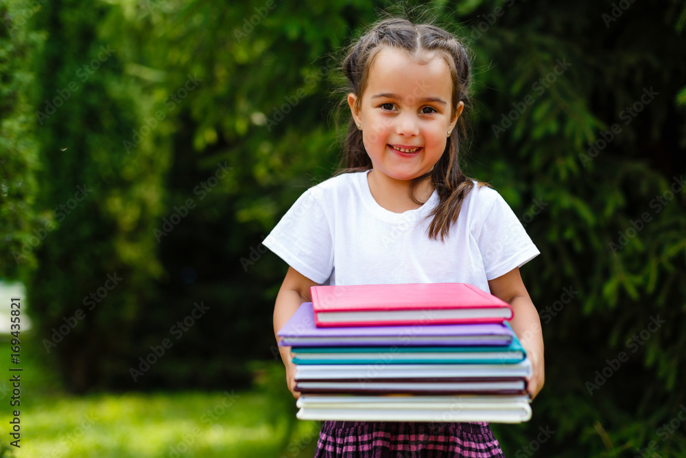 Adorable little schoolgirl in a city park on bright autumn day. Education for young kids. Back to school concept. Adorable little schoolgirl in a city park on bright autumn day. Education for young kids. Back to school concept.