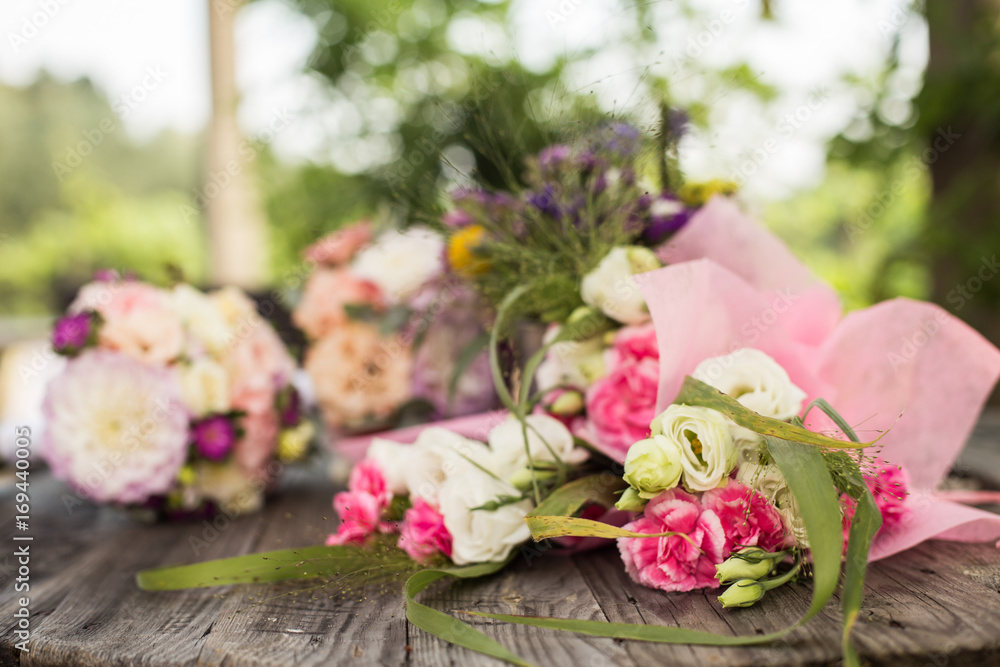 Wedding bouquet with pink, white and violet flowers - set on a wooden table. Wedding bouquet with pink, white and violet flowers - set on a wooden table.
