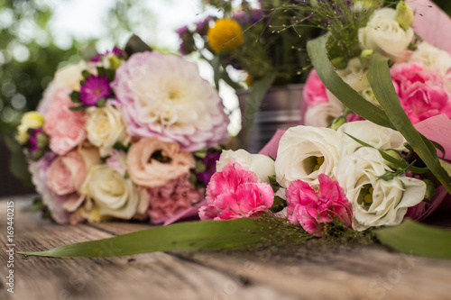 Wedding bouquet with pink  white and violet flowers - set on a wooden table. 