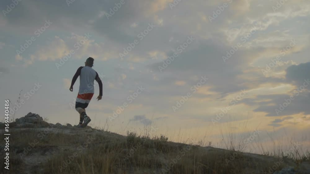 Young Man Running on Mountain Road at Sunset Above the Clouds. Slow Motion HD. Healthy Outdoor Lifestyle. Young Man Running on Mountain Road at Sunset Above the Clouds. Slow Motion HD. Healthy Outdoor Lifestyle.