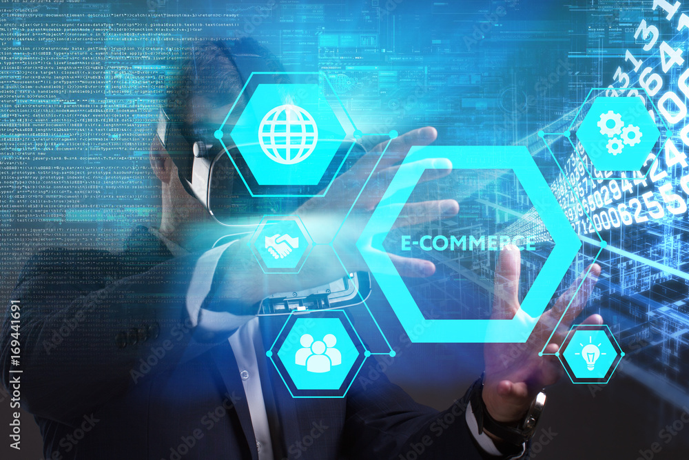 Business, Technology, Internet and network concept. Young businessman working in virtual reality glasses sees the inscription: E-commerce Business, Technology, Internet and network concept. Young businessman working in virtual reality glasses sees the inscription: E-commerce