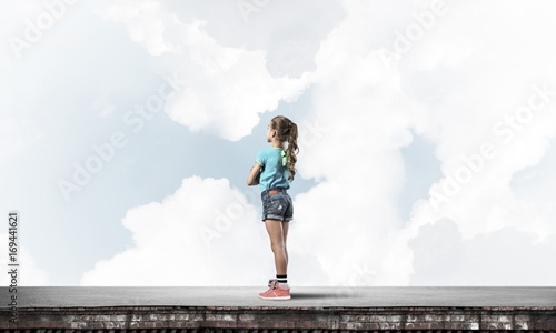 Concept of careless happy childhood with girl looking far away