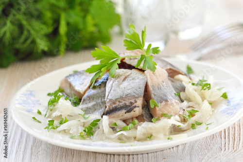 Salted herring fillet with oil, marinated onion and fresh parsley