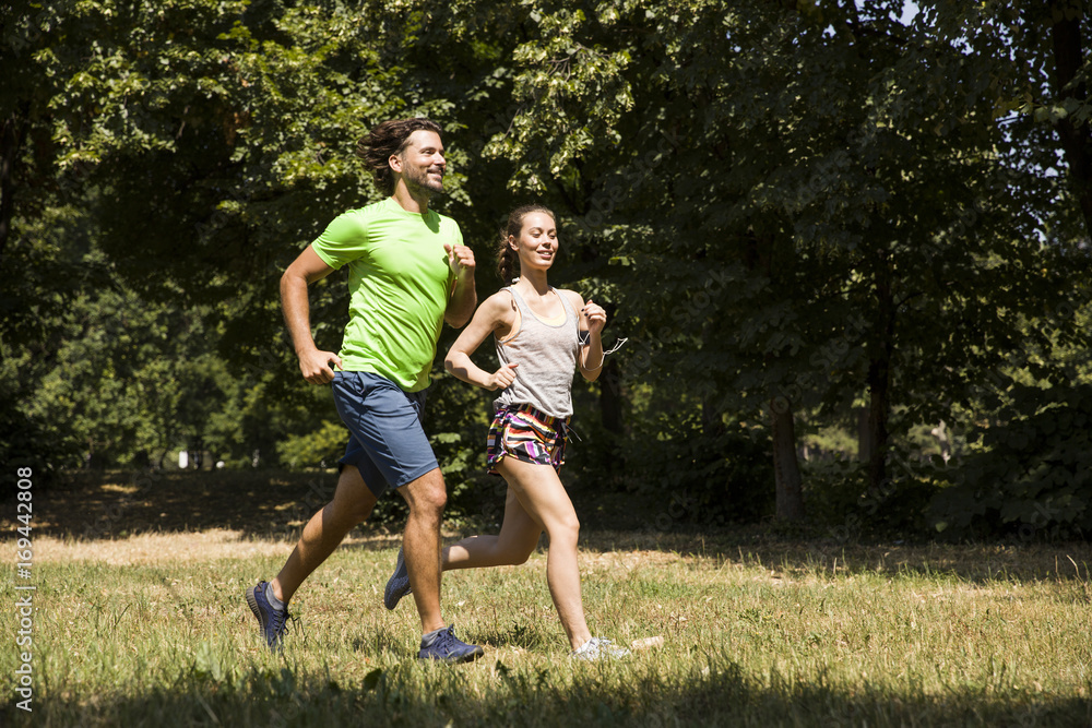 Fototapeta premium Young couple running in nature