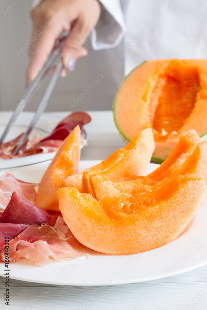 chef preparing dish with melon and ham chef preparing dish with melon and ham