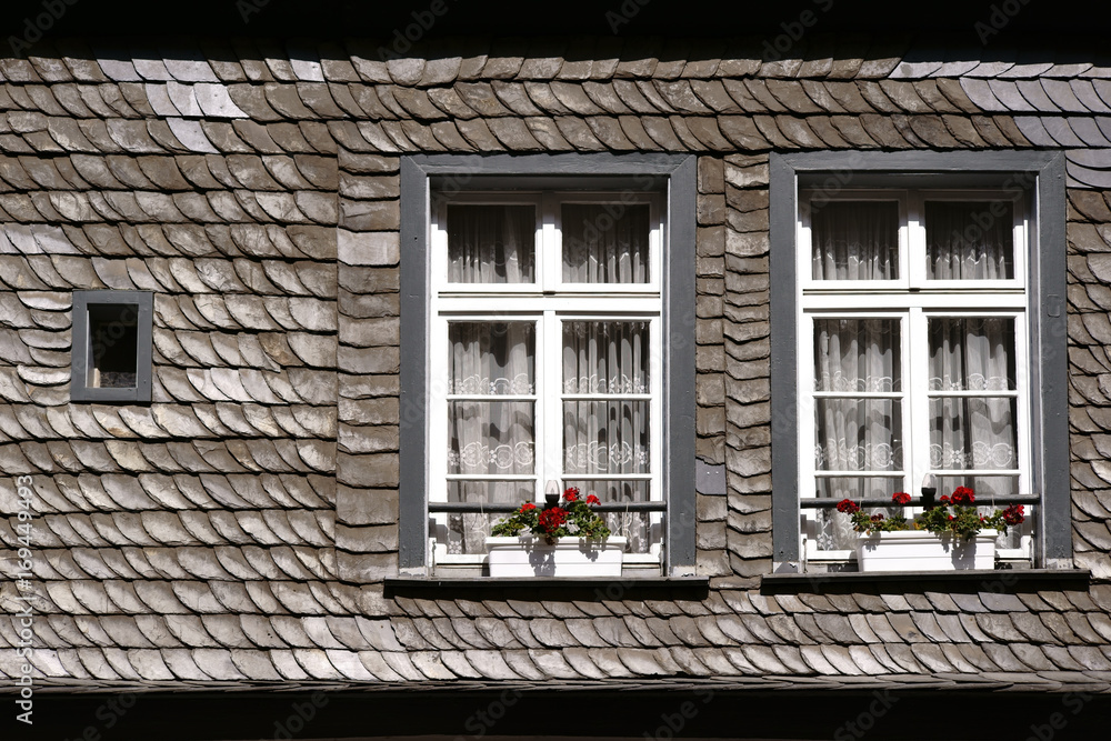Schindeldach mit Dachfenstern  / Ein Schindeldach mit zwei Dachfenstern und Blumenkästen.