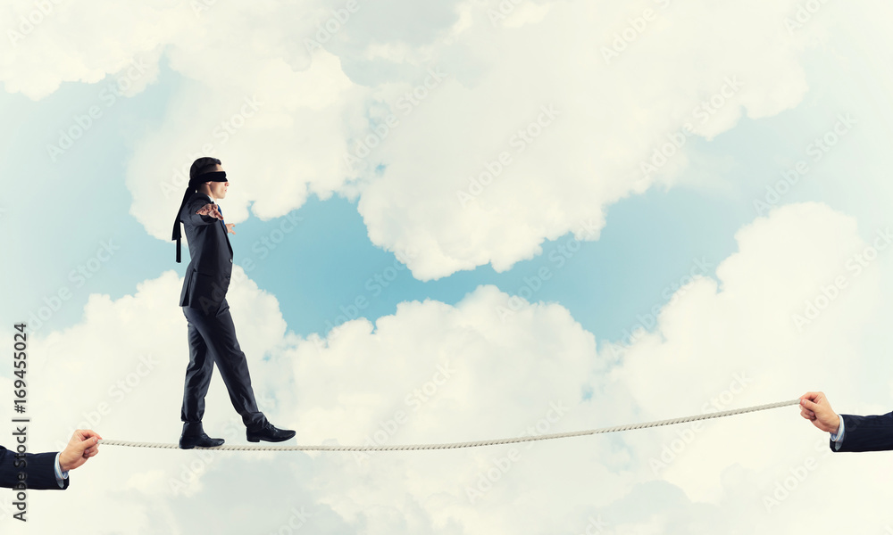 Business concept of risk support and assistance with man balancing on rope Business concept of risk support and assistance with man balancing on rope