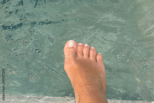 Close up low section of barefeet by the pool at leisure center © OceanProd
