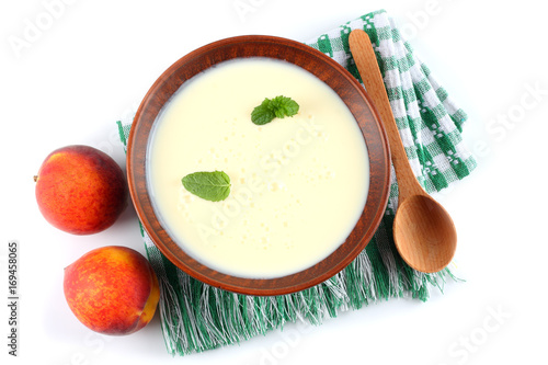 Healthy peach yogurt with peach gruit and mint leaves isolated on white background photo