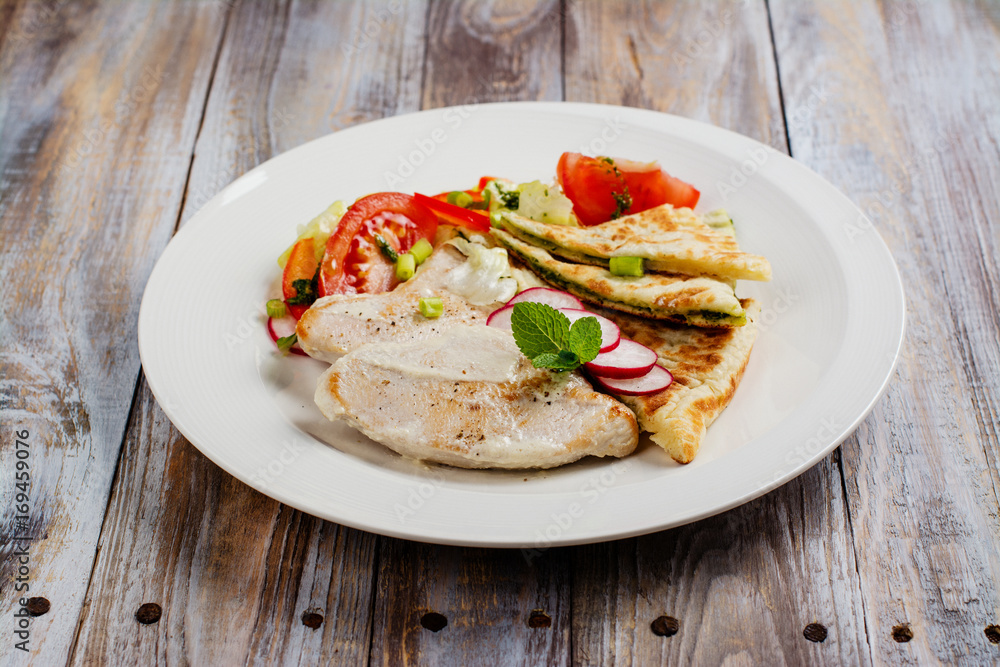 Turkey cutlets served with vegetables, pita bread with pesto and cream sauce. Copy space Turkey cutlets served with vegetables, pita bread with pesto and cream sauce. Copy space