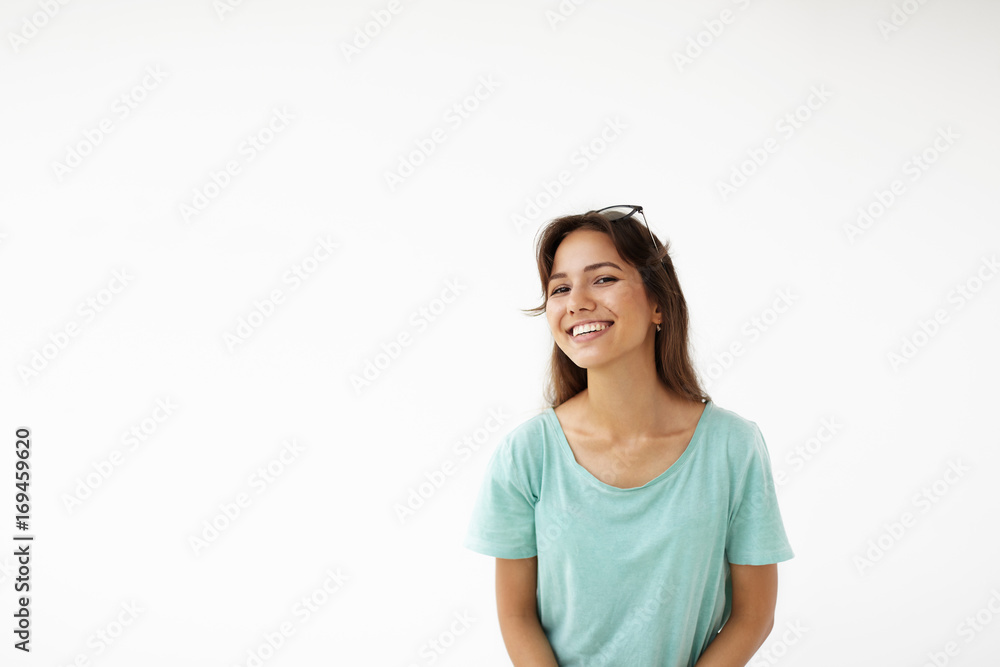 Genuine feelings and emotions. Joy and happiness. Cute young Latin female dressed casually having fun indoors, looking at camera with joyful pretty smile, showing her perfect white straight teeth Genuine feelings and emotions. Joy and happiness. Cute young Latin female dressed casually having fun indoors, looking at camera with joyful pretty smile, showing her perfect white straight teeth