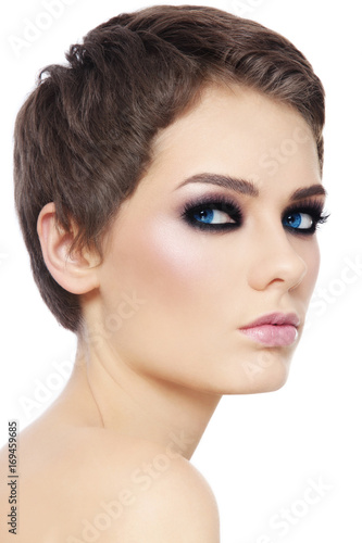Young beautiful woman with pixie haircut and smokey eyes over white background  copy space