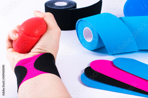 hand with kinesiology tape and stressball. Physiotherapy and therapeutic tape for wrist pain, aches and tension. elastic therapeutic tape. adhesive tape and alternative medicine. photo