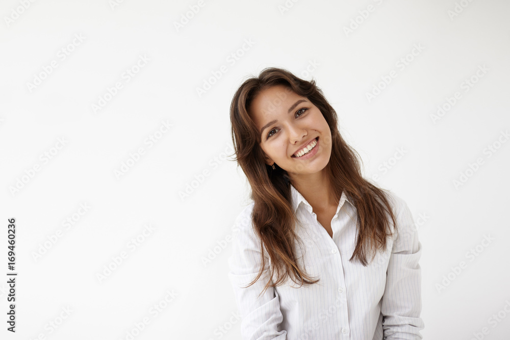 Positive emotions. Picture of successful confident young mixed-race female entrepreneur wearing formal shirt grinning broadly after she made good deal. People, business and lifestyle concept Positive emotions. Picture of successful confident young mixed-race female entrepreneur wearing formal shirt grinning broadly after she made good deal. People, business and lifestyle concept