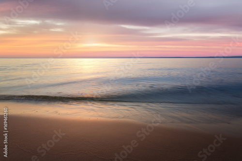 calm water on a background quiet sunset   wild beach dawn alone