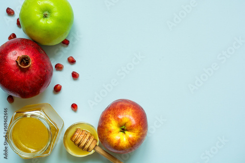 Honey, apple and pomegranate for Rosh Hashanah on blue background