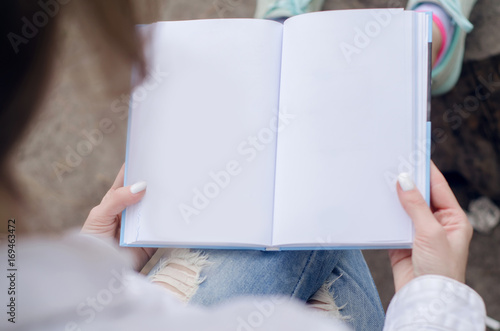 Blank white notebook pages in female hands