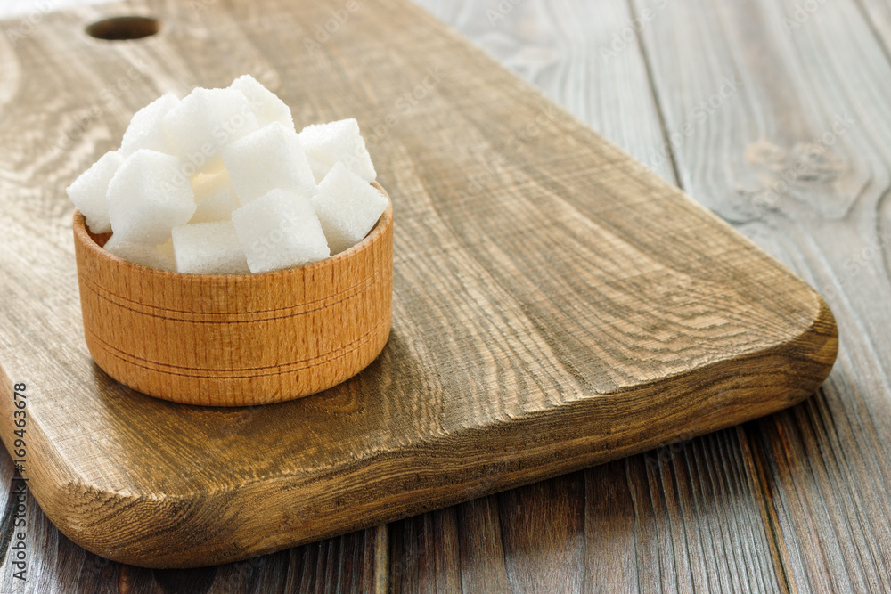 Sugar cubes in bowl on wooden table. White sugar cubes in bowl. Sugar cubes in bowl on wooden table. White sugar cubes in bowl.
