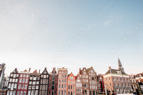 Morning view on the beautiful buildings on the Damrak avenue in Amsterdam. General plan with copy space