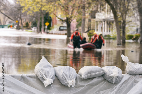 Fotografia Flood Protection Sandbags with flooded homes in the background (Montage)