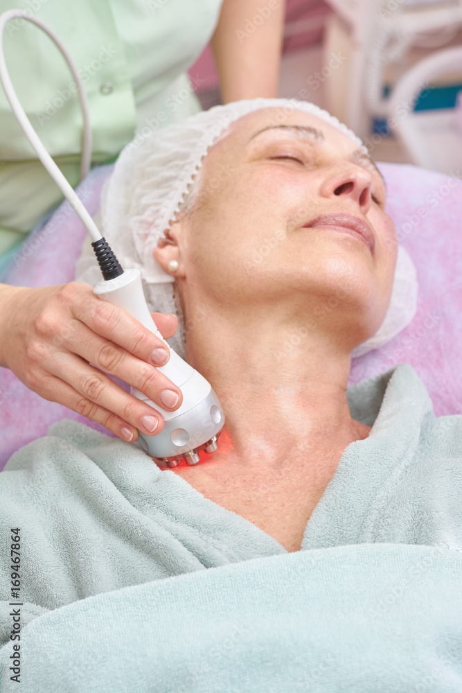 Rf skin tightening procedure. Mature woman, hand of cosmetologist. Health, beauty and rejuvenation.