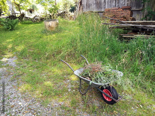 Romantisches Landleben mit Schubkarre auf einem idyllisch gelegenen Bauernhof im Sommer im Pfaffenwinkel in Rudersau bei Rottenbuch im Kreis Weilheim-Schongau in Oberbayern photo