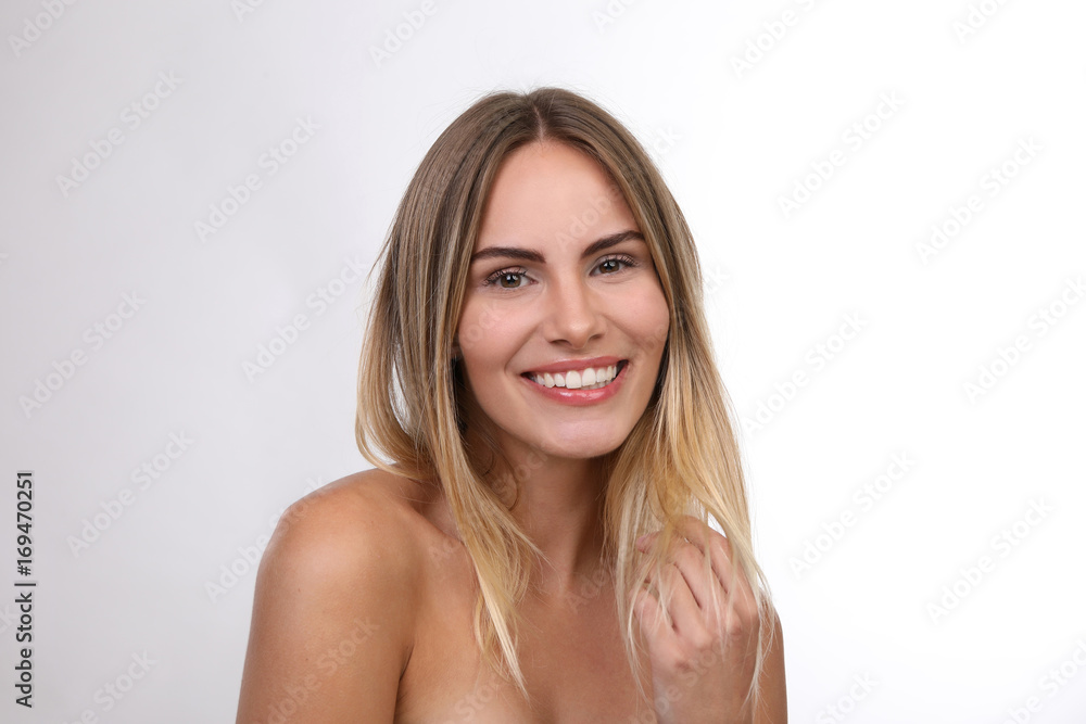 Schöne blonde Frau mit nackten Schultern lacht