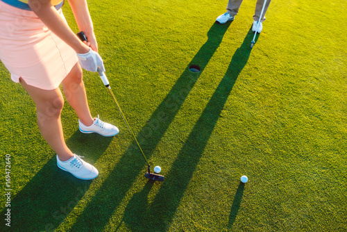 Obraz na plátně High-angle cropped view of a professional woman player holding the putter golf c