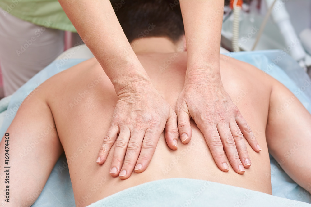 Female hands massaging back. Man having massage. Female hands massaging back. Man having massage.
