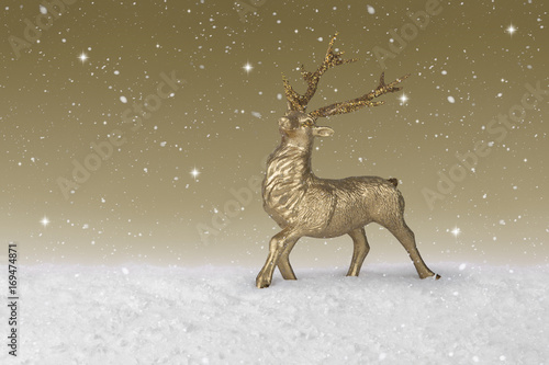 Snow falling on a gold Christmas Reindeer © jasoncoxphotography