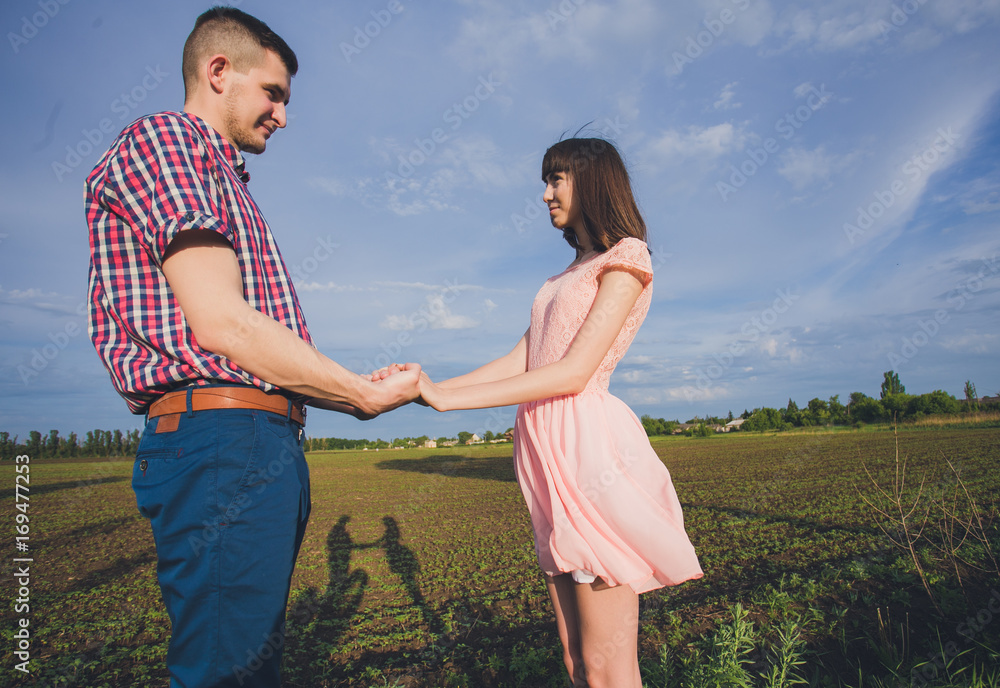 Happy couple on vacation. Lovers are laughing. Happy guy and girl. Lovers enjoy each other in the evening park. Happy couple on vacation. Lovers are laughing. Happy guy and girl. Lovers enjoy each other in the evening park.