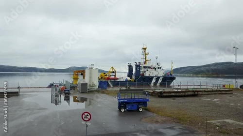 The rise of the quadcopter in a Norwegian port in the background of the moored ship photo