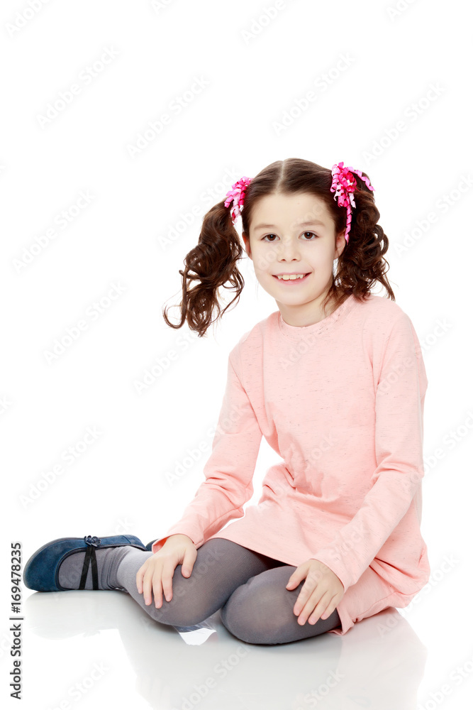 Little girl sitting on the floor and straightens hair. Little girl sitting on the floor and straightens hair.